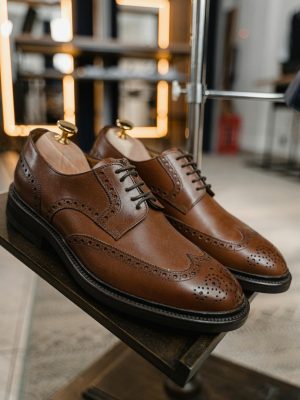 Pair of classic brown leather brogue shoes showcased in a stylish setting.