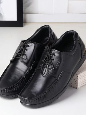 Sleek black leather men's shoes displayed on a decorative box, perfect for formal occasions.